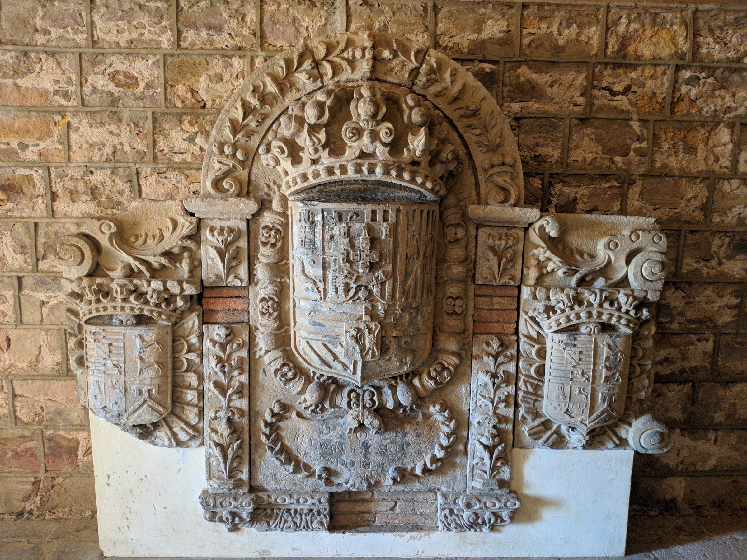 Three carved coats of arms on a historic wall in Barcelona’s Gothic Quarter